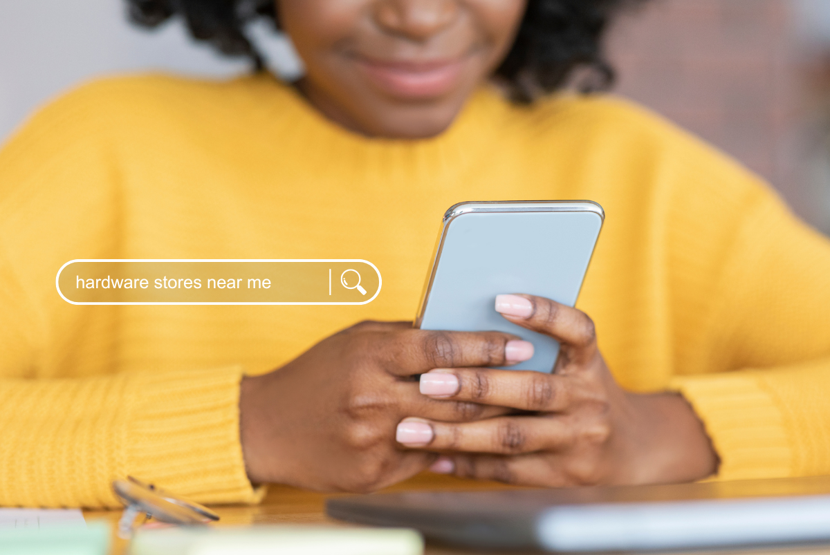 Woman on phone searching for hardware stores near her.